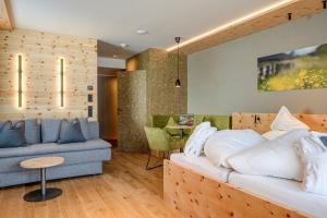 a living room with a bed and a couch at Naturhotel Tandler in Sankt Jakob in Defereggen