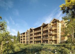 a large apartment building on a hill with trees at Appartement sur Valberg dans résidence neuve proche centre in Valberg