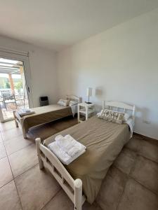 a bedroom with two beds and a balcony at Pergolas Guest House - Pileta, Vinos y Montaña in Vista Flores