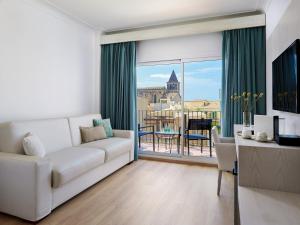 a living room with a white couch and a large window at Hotel Saratoga in Palma de Mallorca