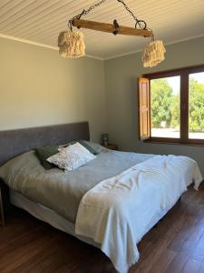 1 cama en un dormitorio con 2 lámparas de araña en Casa Rincon Radales en San Martín de los Andes