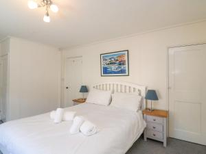 a bedroom with a bed with white sheets and pillows at Lobster Cottage in Weymouth