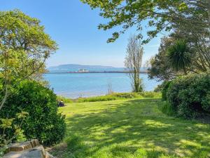 a view of the water from a park with a green lawn at Lobster Cottage in Weymouth