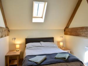 a bedroom with a bed with two lamps and a window at The Barn - 19202 in Compton