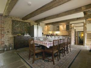 Old Rectory Barn في Fernhurst: مطبخ مع طاولة وكراسي وثلاجة