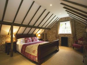 1 dormitorio con cama y pared de ladrillo en Old Rectory Barn, en Fernhurst
