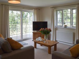a living room with a tv and a coffee table at Bardon Lodge in Denbury
