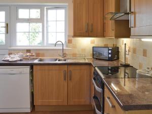 a kitchen with a sink and a microwave at Bardon Lodge in Denbury