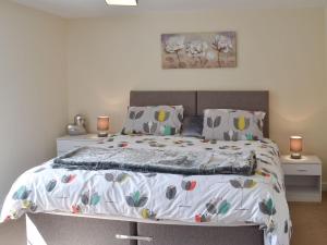 a bedroom with a bed and two night stands at Bardon Lodge in Denbury