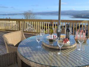 una mesa con botellas de vino y copas en el balcón en Balnacraig, en North Kessock