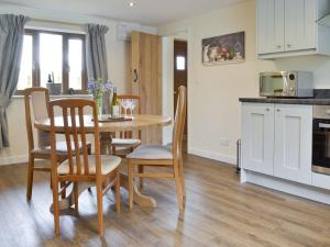 cocina y comedor con mesa y sillas en The Lodge, en Wedmore