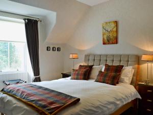 Creag Darach Cottage في أبرفويل: غرفة نوم بسرير كبير مع وسادتين