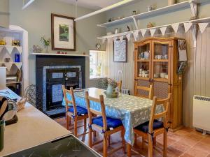 Creag Darach Cottage في أبرفويل: مطبخ مع طاولة وكراسي ومدفأة