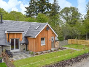 a small wooden house with a yard at Anemone in Kenmore