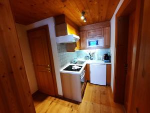 La cuisine est équipée de placards en bois et d'une cuisinière blanche. dans l'établissement Ferienwohnung Drexel, à Steeg