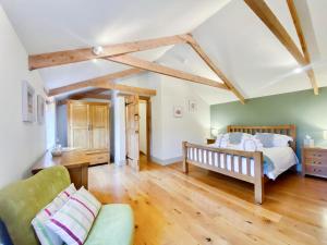 a bedroom with a bed and a couch in a room at Budding - Uk4269 in Dyrham