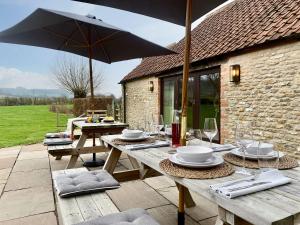 a wooden table with an umbrella on a patio at Budding - Uk4269 in Dyrham