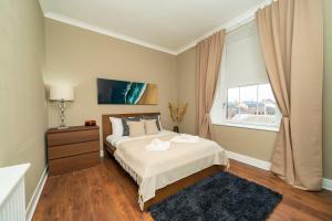 Un dormitorio con una cama grande y una ventana en 1 Shore, en Arbroath