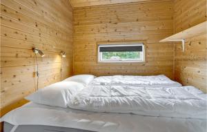 two beds in a wooden room with a window at Nice Home In Kolding With House A Panoramic View in Kolding