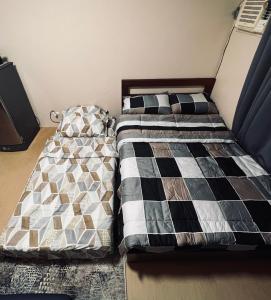 dwa łóżka siedzące obok siebie w sypialni w obiekcie B Avida Tower w mieście Iloilo