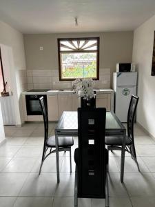 uma cozinha com uma mesa com cadeiras e uma janela em Maison T3 neuve fonctionnelle em Matoury