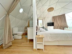 a bedroom with a tent with a bed and a toilet at Domo Volcano Suite Experience in Arafo