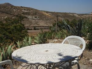 a white table and chairs with a mountain in the background at Cuevas La Veranda in Orce