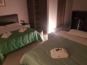 Your Home in Naples في نابولي: غرفة نوم بسريرين عليها مناشف