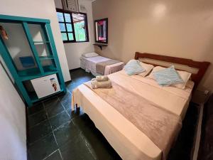 a bedroom with two beds and a mirror at Pousada Paloma in Abraão
