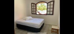 a small bedroom with a bed and a window at Casa de Praia Barra da Ibiraquera in Imbituba