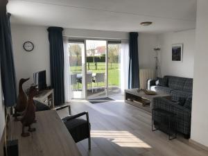 a living room with a couch and a table at Kustverhuur, Park Scheldeveste, Zwin 116 in Breskens