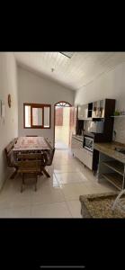 a large room with a table and a kitchen at Casa de Praia Barra da Ibiraquera in Imbituba