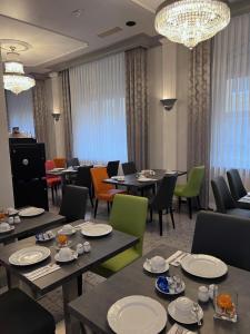 a dining room with tables and chairs and chandeliers at Apartment Hotel KRAL - BUSINESS HOTEL & SERVICED APARTMENTS in Erlangen +41 photos