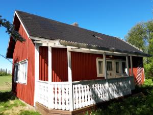 una casa roja y blanca con una valla blanca en Kesäranta, en Tynkä