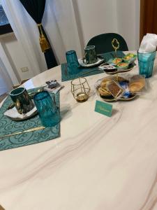 un tavolo con piatti e bicchieri di B&B Smeralda a Villa San Giovanni