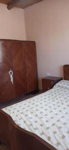 1 dormitorio con 1 cama grande y armarios de madera en Finca del Sol Naciente en Monte Comán