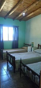 1 dormitorio con 2 camas y ventana en Finca del Sol Naciente en Monte Comán