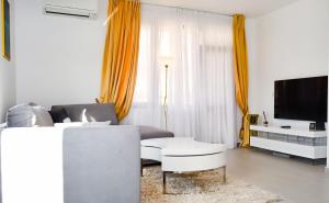 uma sala de estar com um sofá e uma televisão em Apartment with balcony, Lighthouse Golf Resort, 62sqm em Balchik