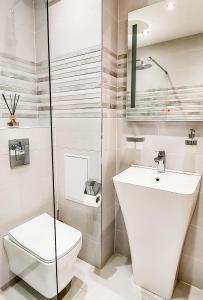 a white bathroom with a toilet and a sink at Apartment with balcony, Lighthouse Golf Resort, 62sqm in Balchik