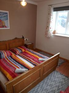 a bedroom with a bed with a colorful comforter and a window at Chalet Rosemarie in Bad Gastein