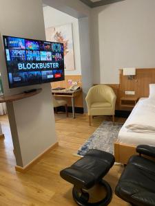 a living room with a flat screen tv on a wall at The KRAL - Business Hotel & Serviced Apartments in Erlangen