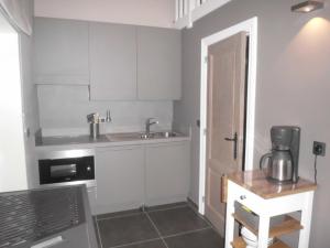 eine Küche mit weißen Schränken und einem Waschbecken in der Unterkunft Vakantiewoning 't Blooteland in Diksmuide