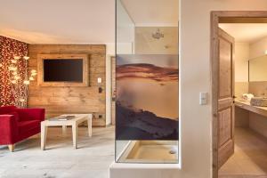 a living room with a red couch and a tv at Dolomit Boutique Hotel in La Villa