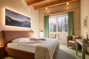 Un dormitorio con una cama grande y una ventana en Dolomit Boutique Hotel en La Villa