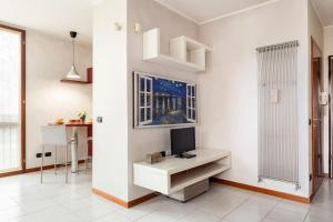 salon z telewizorem na białej ścianie w obiekcie Forum Assago appartamento w mieście Assago
