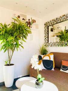 a living room with two potted plants and a couch at Un nid à Saint Tropez in Saint-Tropez