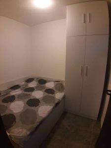ein kleines Schlafzimmer mit einem Bett und einem weißen Schrank in der Unterkunft TOP view Apartment Budva in Budva