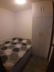 a small bedroom with a bed and a white cabinet at TOP view Apartment Budva in Budva