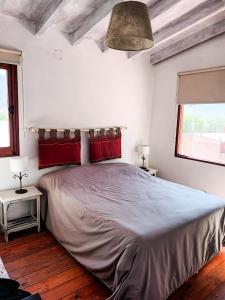 1 dormitorio con 1 cama grande con almohadas rojas en Cabañas La Sorpresa en Tilcara