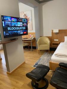 a living room with a flat screen tv on a wall at Work & Travel - KRAL Hotels Erlangen in Erlangen